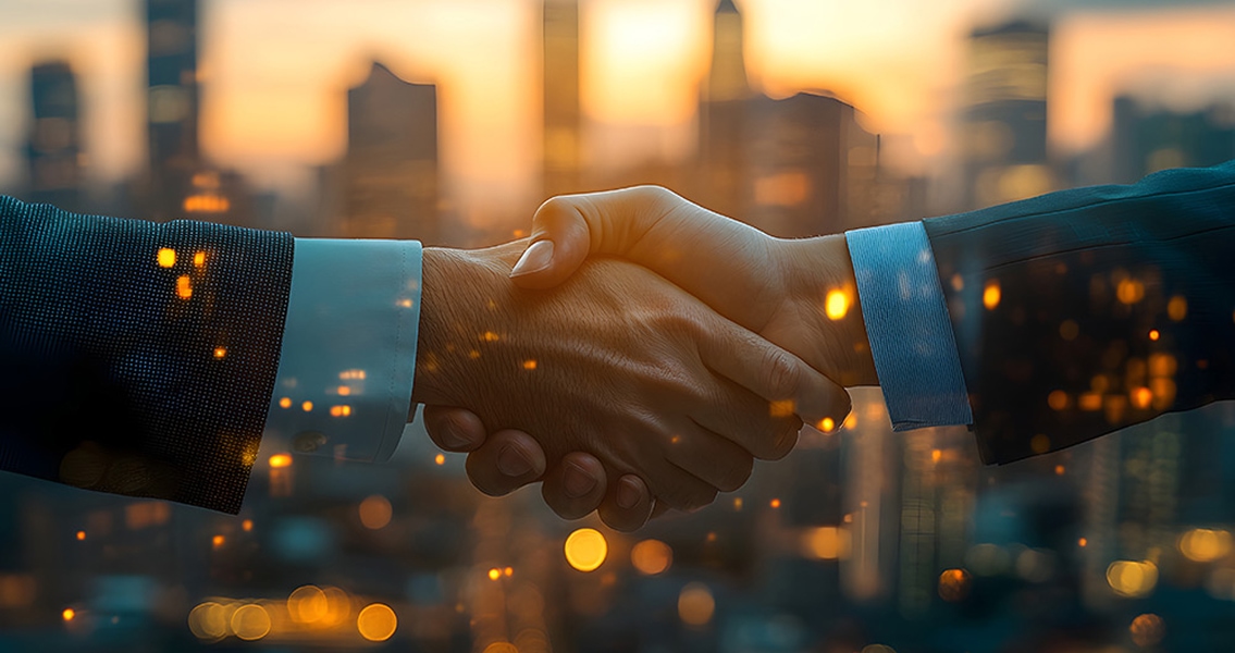 Two individuals in suits shaking hands, set against a blurred cityscape at dusk. The scene conveys professionalism and partnership, illuminated by warm city lights.
